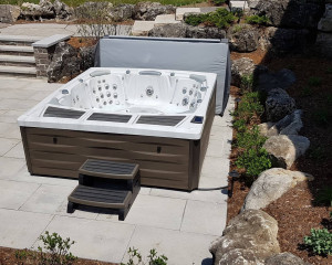 Hot tub installed in a backyard on a patio.