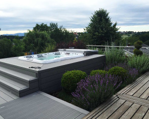 Sundance Spas hot tub installed in the ground in a backyard space.
